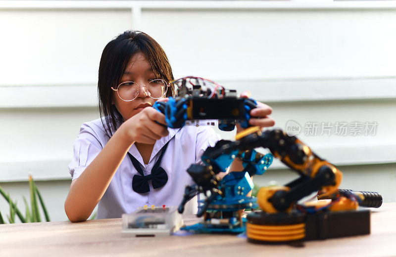 年轻的亚洲女孩放学后在家学习Robot KIT，科技学习理念